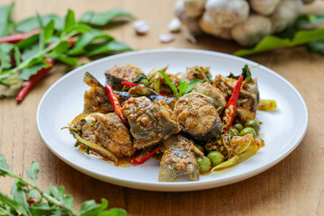 Spicy stir-fried catfish (Pad Cha Pla Dook) on a white plate, a popular and flavorful Thai dish....