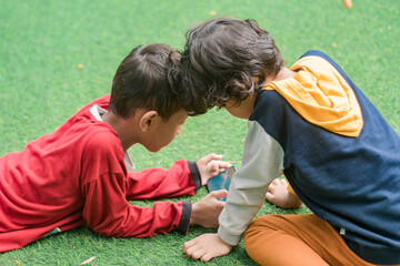 Portrait of two little children at park full of grass