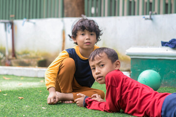 Portrait of two little children at park full of grass