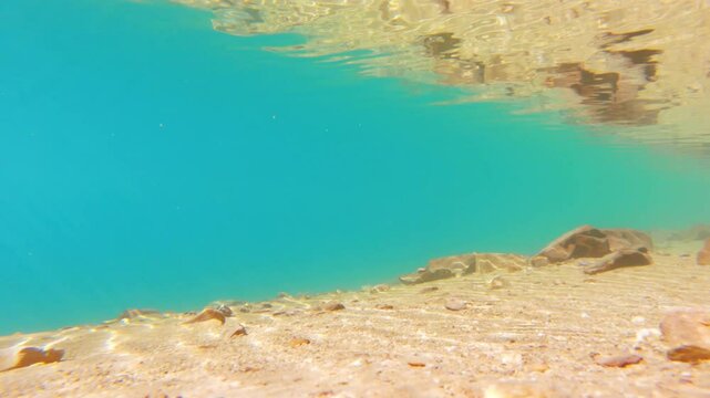 4K Under water shot of crystal clear water of the Chandra Taal Lake with sun rays visible through the clear water during a sunny day at Lahaul and Spiti district, Himachal Pradesh, India. Scenic Lake.