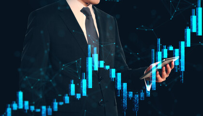 Businessman holding smartphone with financial growth chart hologram overlay on dark background, symbolizing market analysis and investment concept.