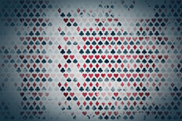 Repeating pattern of playing card suits with vintage texture on faded grunge backdrop forming...