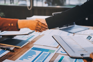Two diverse professional business men executive leaders shaking hands at office meeting