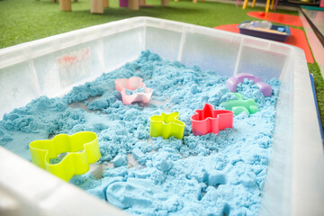 Set of different cute toys in children's playground. Preschool building exterior with playground and toys on a sunny day