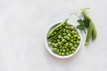 Fresh green peas beans in a white plate, copy space