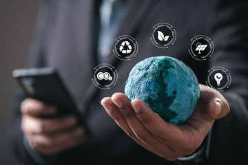 A person holds a small globe while using a smartphone, surrounded by icons representing...