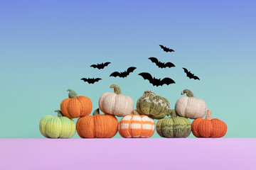 Knitted orange, green and gray pumpkins with black bats on blue green gradient background, autumn...