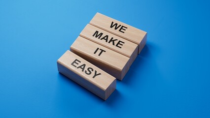 We make it easy symbol. Concept words We make it easy on wooden blocks. Business motivational we make it easy concept. Copy space.3D rendering on blue background.