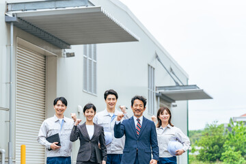 建物の前でガッツポーズする会社従業員のグループ