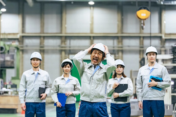 工場の中でショックを受ける作業員リーダー