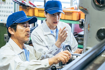 工場で機械を操作する男性作業員のグループ