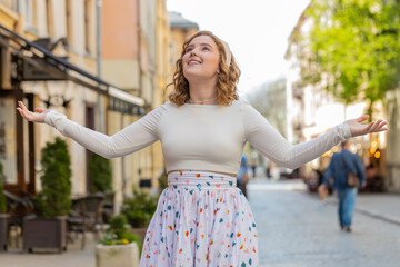 Redhead woman in long dress taking a deep breath of fresh air, relaxing, taking a break, resting,...