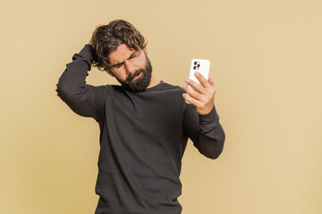 Lebanese young man using mobile cell phone typing browsing, loses becoming surprised sudden lottery...