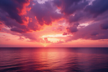 Obraz premium pink sunset over the ocean with clouds reflecting in the water
