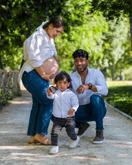 Fototapeta premium Father and pregnant mother with son outdoors