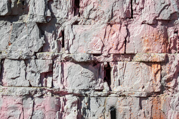 Old painted dilapidated brick close-up in sunny weather as a background.