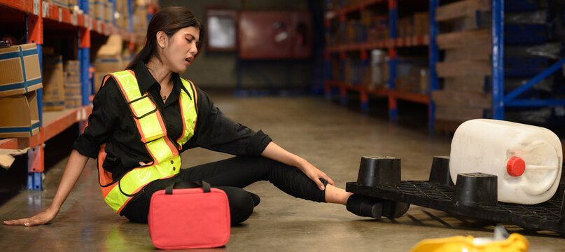 First aid support accident at work of worker at factory. Male worker has an accident on the floor in warehouse site.