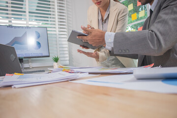 Two experts in a modern Australian conference room analyze charts, discuss strategies and present financial data to plan growth, profits and success.