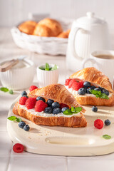 Hot and homemade french croissant with cottage cheese and berries.