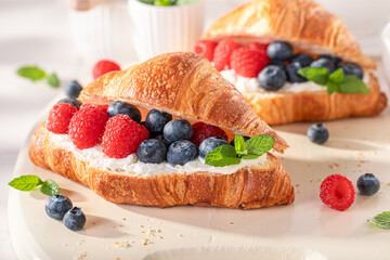 Golden and sweet french croissant with cottage cheese and berries.