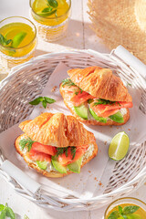 Hot and golden french croissant with avocado and salmon.