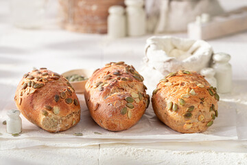 Homemade buns with pumpkin seeds in rustic kitchen.