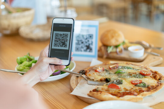 Woman use smartphone to scan QR code for order menu in cafe restaurant with a digital delivery. Choose menu and order accumulate discount. E wallet, technology, pay online, credit card, bank app.
