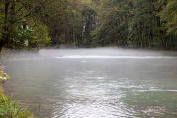 Source of the Bosna River, Sarajevo-Ilidza. Mist rises from a tranquil Bosna River surrounded by...