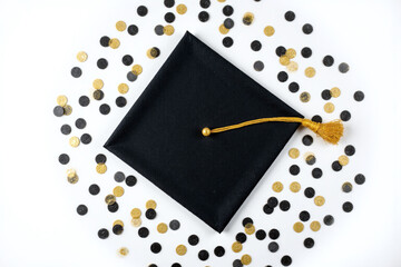 black graduation cap with gold confetti on a white background