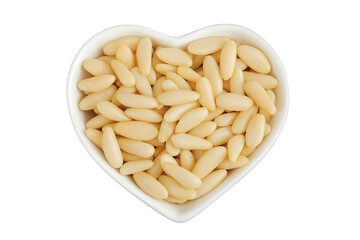 Shelled European pine nuts in ceramic bowl isolated on white background with full depth of field....