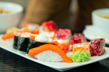 Colorful assortment of authentic sushi rolls and nigiri with fresh seafood. Beautiful presentation of nutritious Japanese fast food.