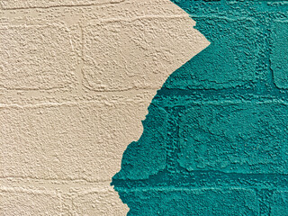 Colorful wall with peeling paint revealing contrasting surface underneath in urban setting