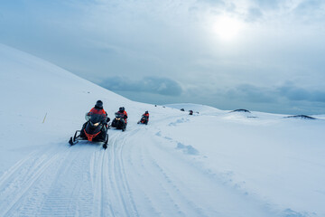 Snowmobile adventure across snowy mountain track in winter