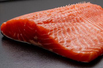Fresh raw salmon or trout fillet. Fish for sushi. Preparing fish for cooking. Black background....