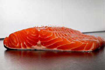 Fresh raw salmon or trout fillet. Fish for sushi. Preparing fish for cooking. Black background. Healthy seafood food.