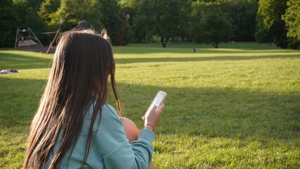 young woman with mobile phone in the park
