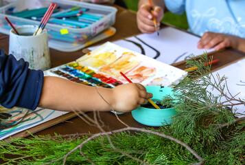 Children painting with watercolors outdoors on a sunny day