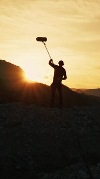 Silhouette Of Film Sound Recordist Is Capturing Background Nature On Mountains