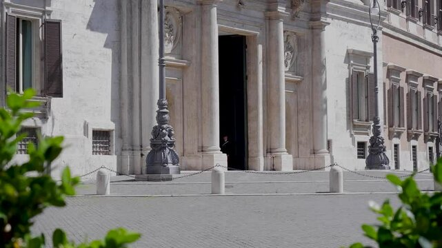 Palazzo Chigi, residence of Italian prime minister, camera tilt up panning right to top of Column of Marcus Aurelius at Piazza Colonna in Rome, Italy