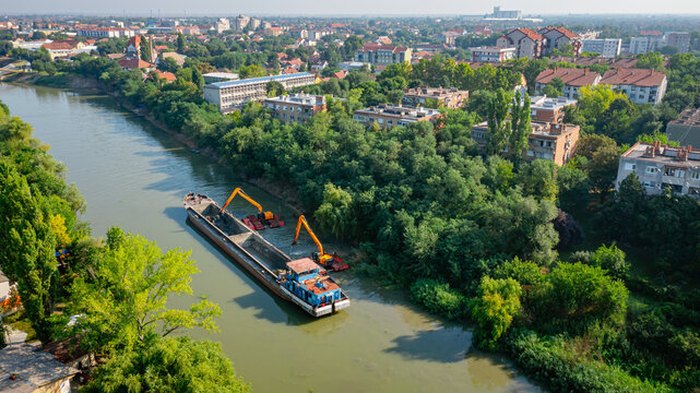 Fototapeta Aerial view of river, canal is being dredged by excavators