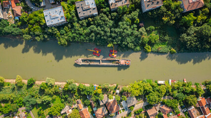 Aerial view of river, canal is being dredged by excavators