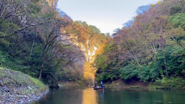 Tourists Enjoying Autumn Scenery on Traditional Boat Ride at Geibikei Gorge, Japan.