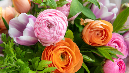 Spring bouquet. Beautiful pastel colored fresh flowers arrangement. Birthday bouquet made of tulips and ranunculus photographed outdoors.