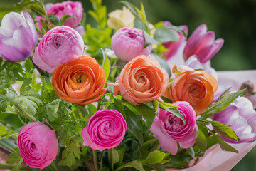 Spring bouquet. Beautiful multi colored fresh flower arrangement. Birthday bouquet made of tulips and ranunculus photographed outdoors.