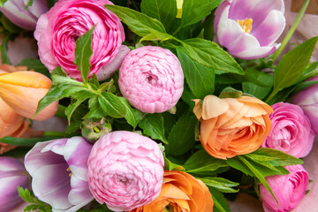 Spring bouquet. Beautiful pastel colored fresh flowers arrangement. Birthday bouquet made of tulips and ranunculus photographed outdoors.