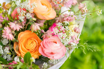 Spring mixed ranunculus bouquet. Beautiful pastel colored fresh flowers arrangement. Birthday bouquet made of ranunculus photographed outdoors.