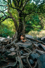 Travel people make yoga meditation under beautiful tropical tree
