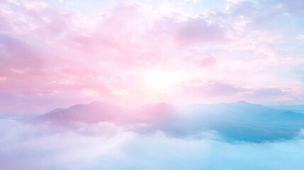 Naklejka premium Pastel sunrise over a mountain range shrouded in clouds.