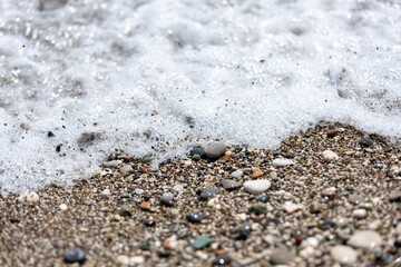 sea foam on the sand with pepples