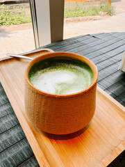 Relaxing matcha drink served in a ceramic bowl at a cafe during a sunny afternoon